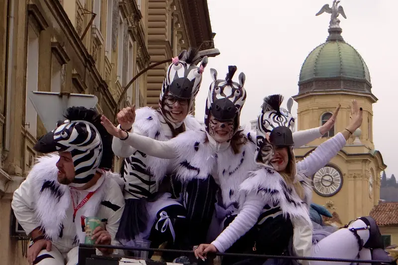 A carnival group in zebra costumes in front of Rijeka's City Clock Tower